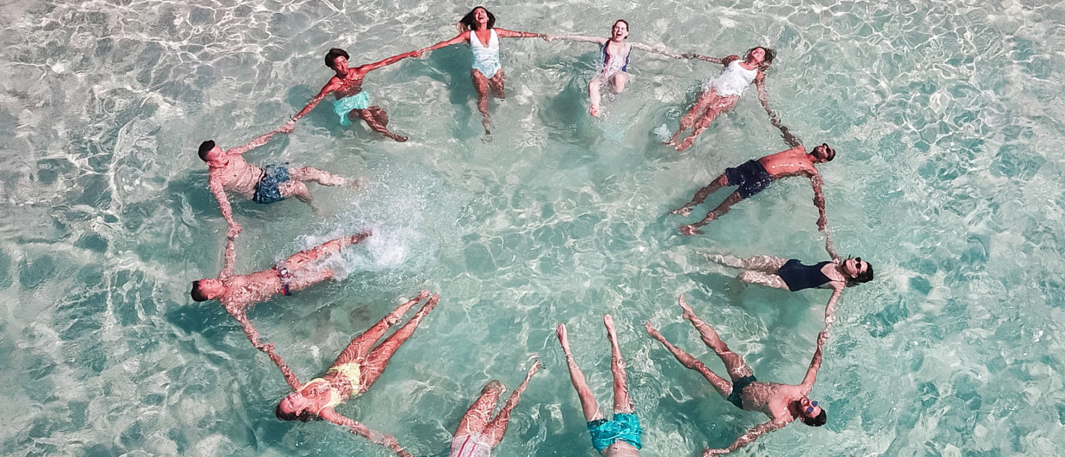 People floating together in clear Hawaii water